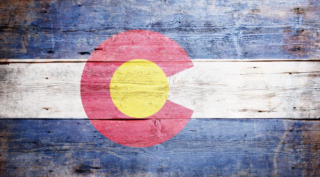 Flag of the state of Colorado painted on grungy wooden background