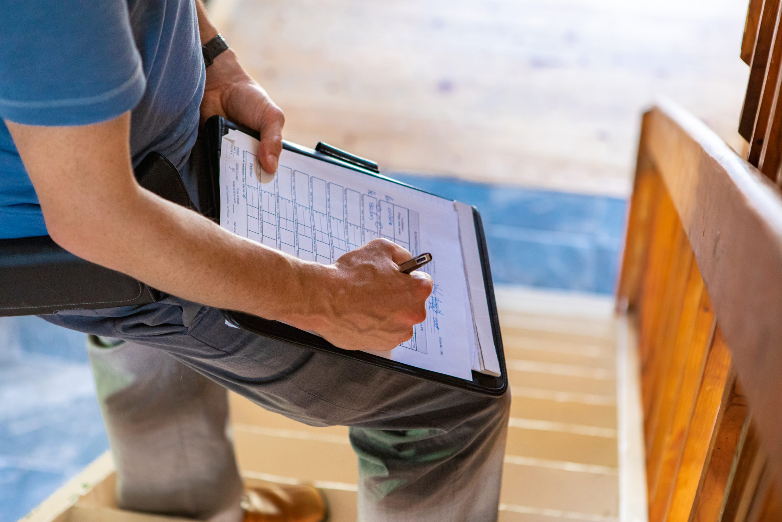 professional male wearing blue t-shirt, writing out forms during a home inspection